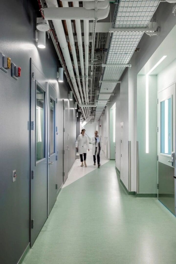 A hallway with two people walking in it