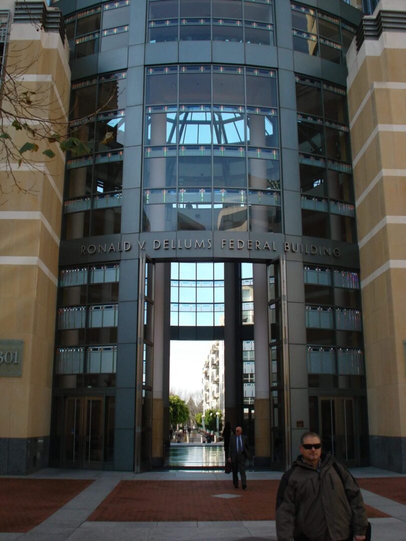 A person sitting in front of an entrance to a building.