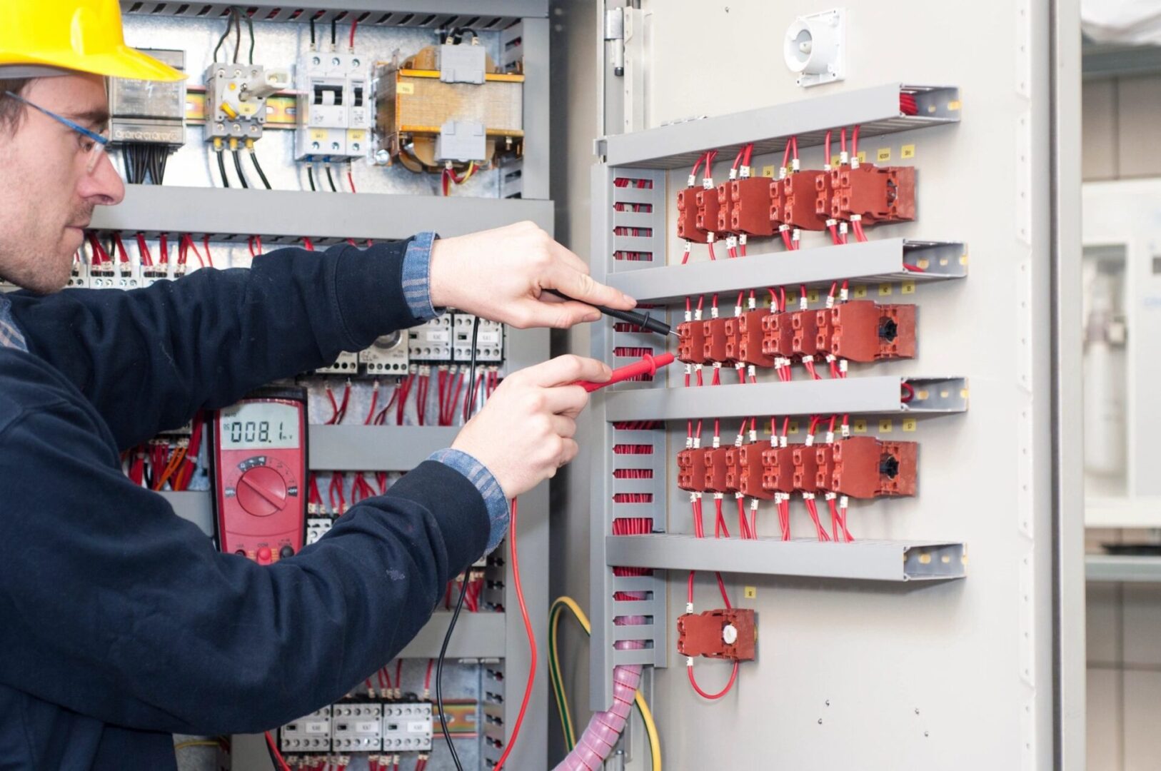 A person is working on an electrical panel.